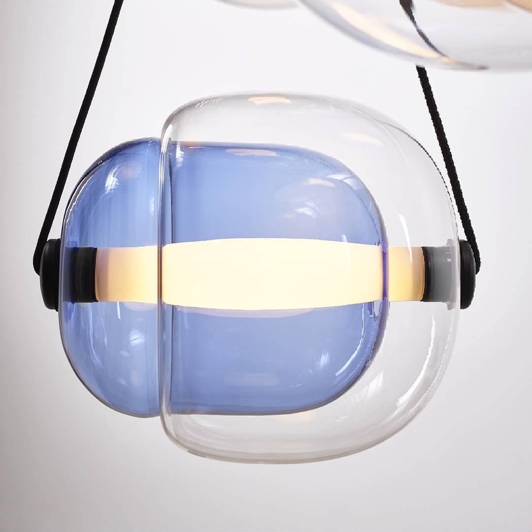 Capsula Pendant Light in Blue Clear glass with dimensions of ∅ 12.6″ x H 10.2″ (Dia 32cm x H 26cm) and Cold white illumination.